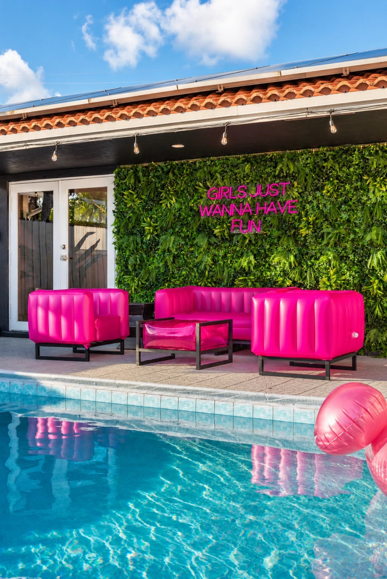 Swimming pool and bright pink patio seating at The Jungle