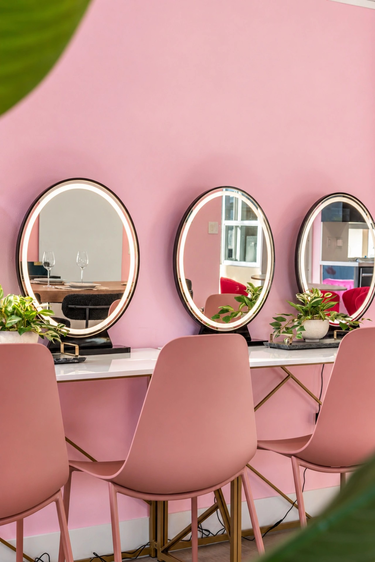 Pink get-ready room with mirrored styling stations