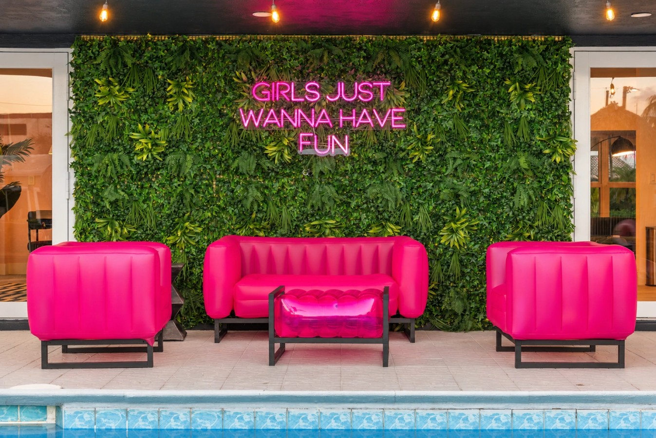 Swimming pool and bright pink patio seating at The Jungle