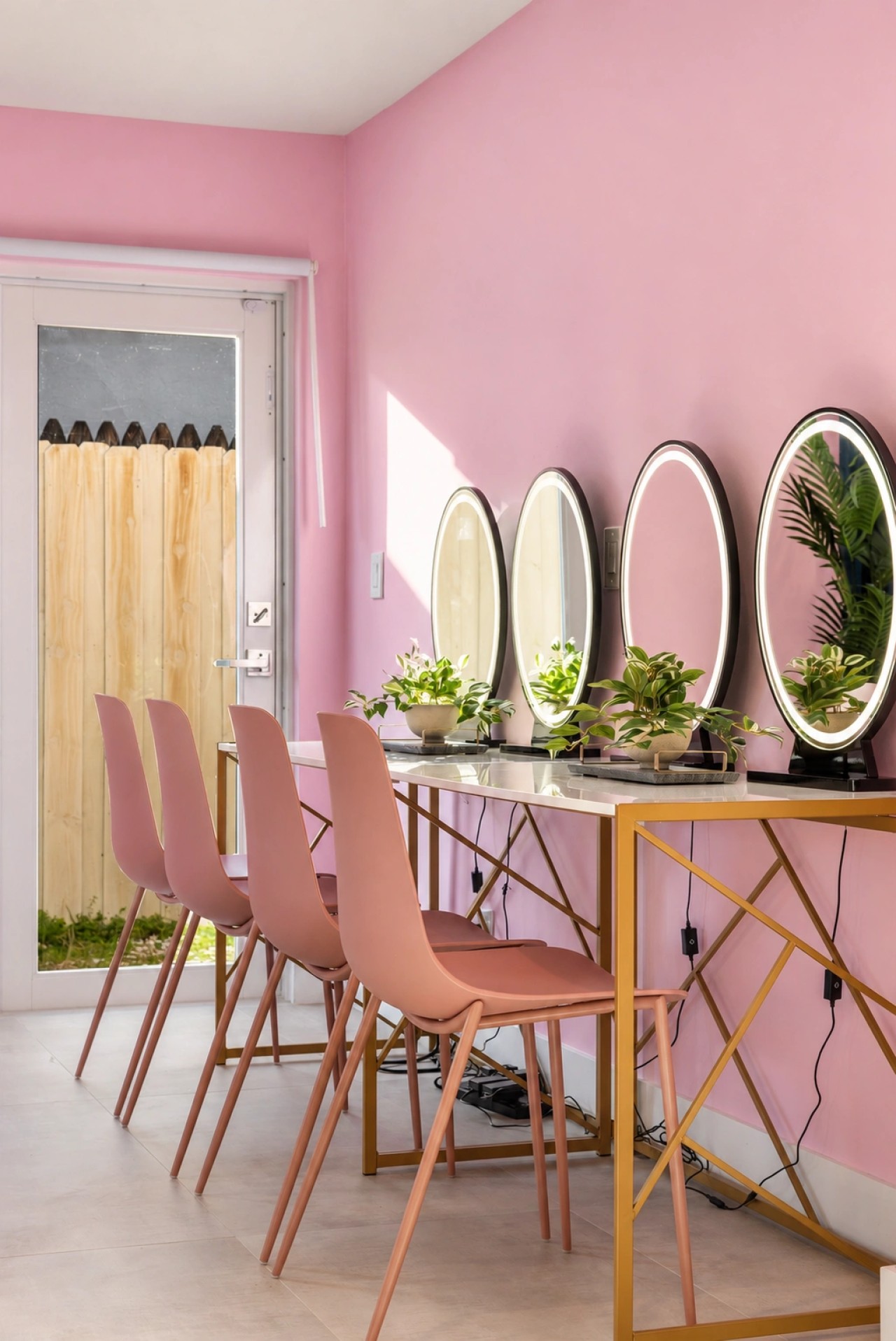 Pink get-ready room with mirrored styling stations