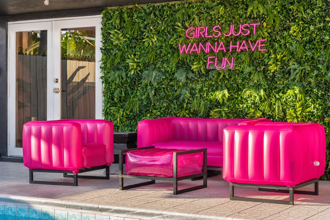 Swimming pool and bright pink patio seating at The Jungle