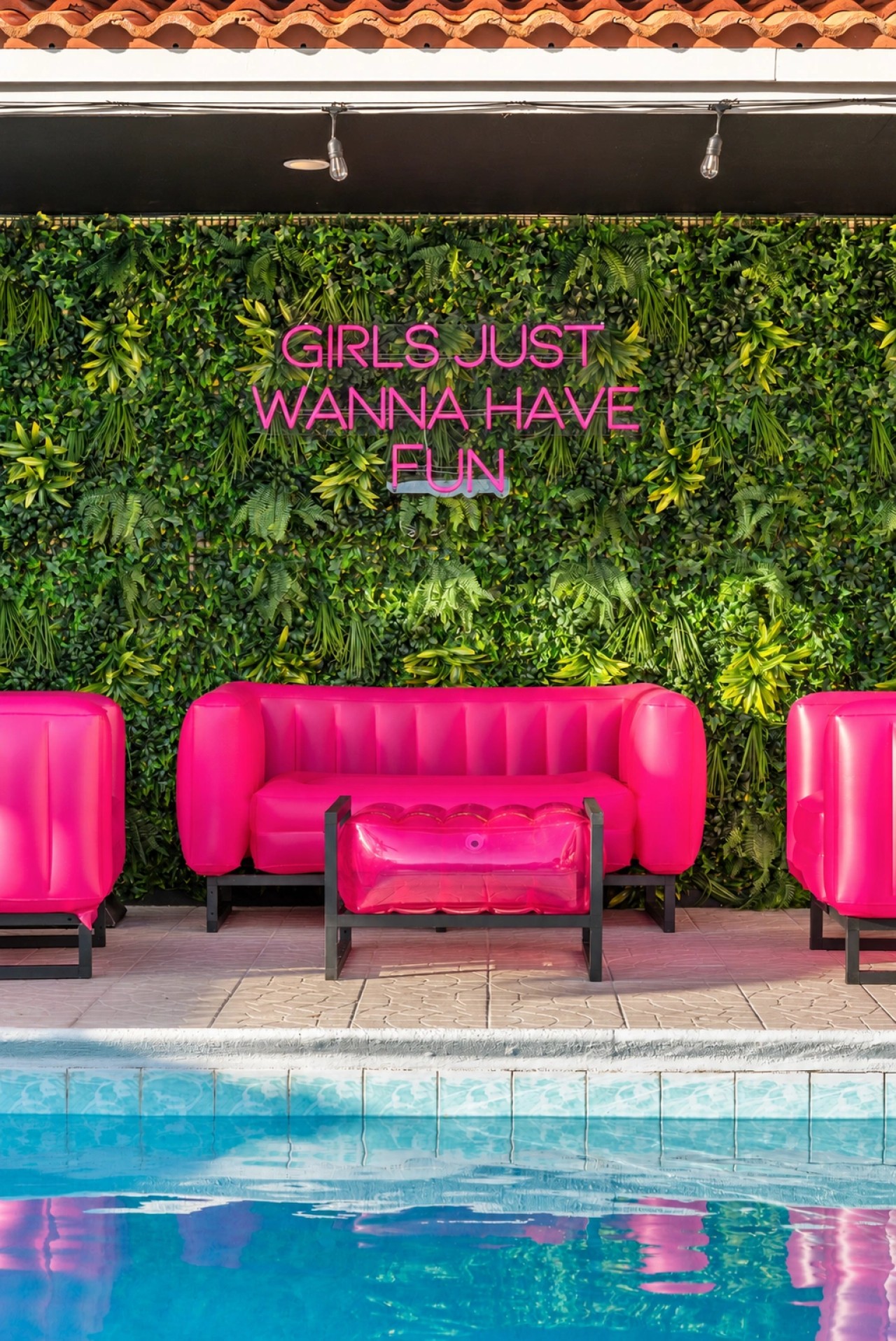 Swimming pool and bright pink patio seating at The Jungle