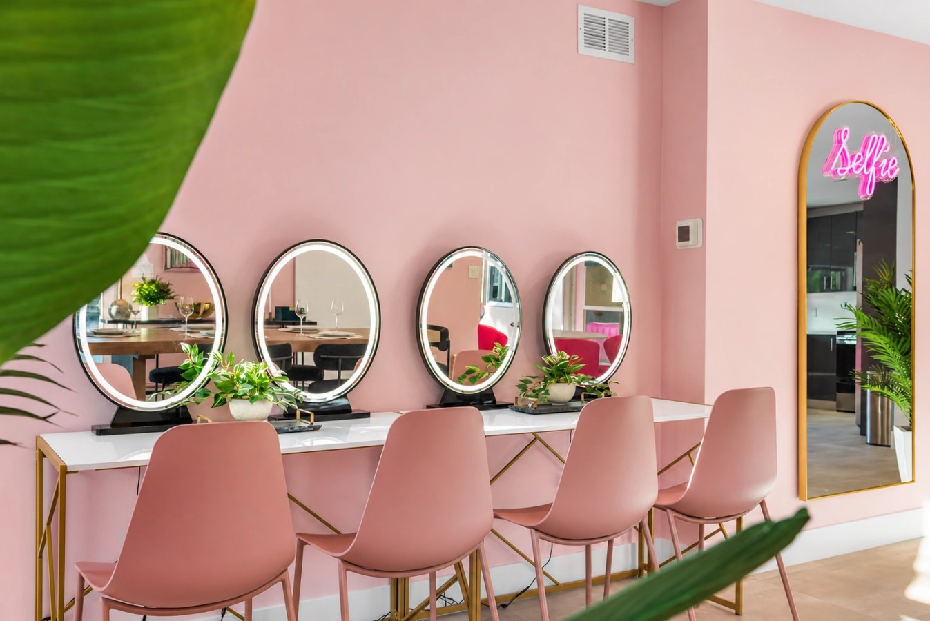 Pink get-ready room with mirrored styling stations