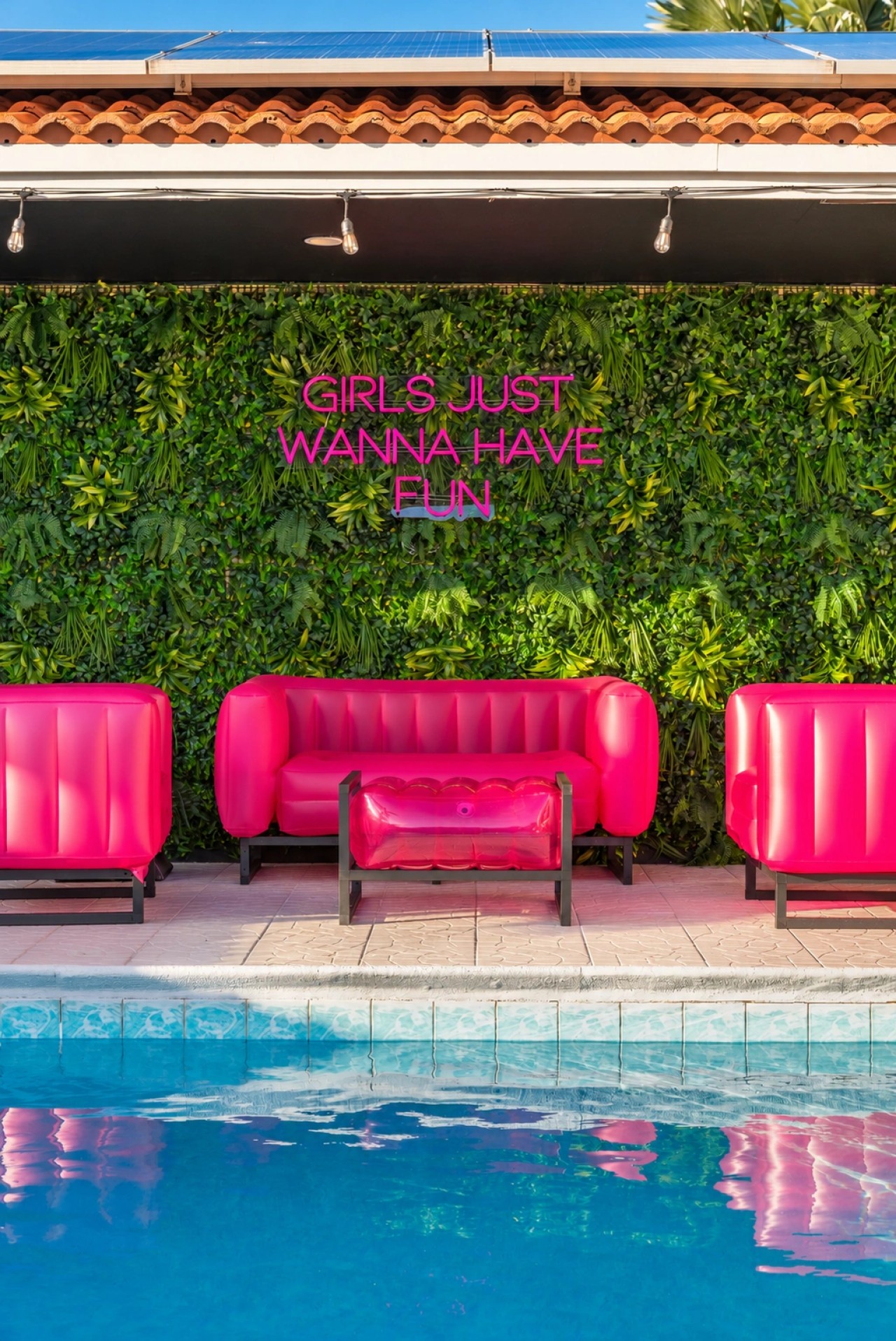 Swimming pool and bright pink patio seating at The Jungle