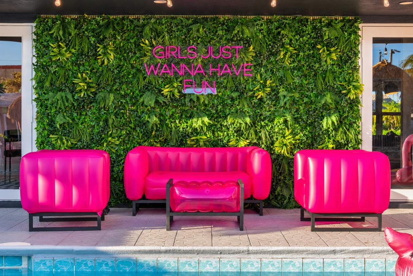 Swimming pool and bright pink patio seating at The Jungle