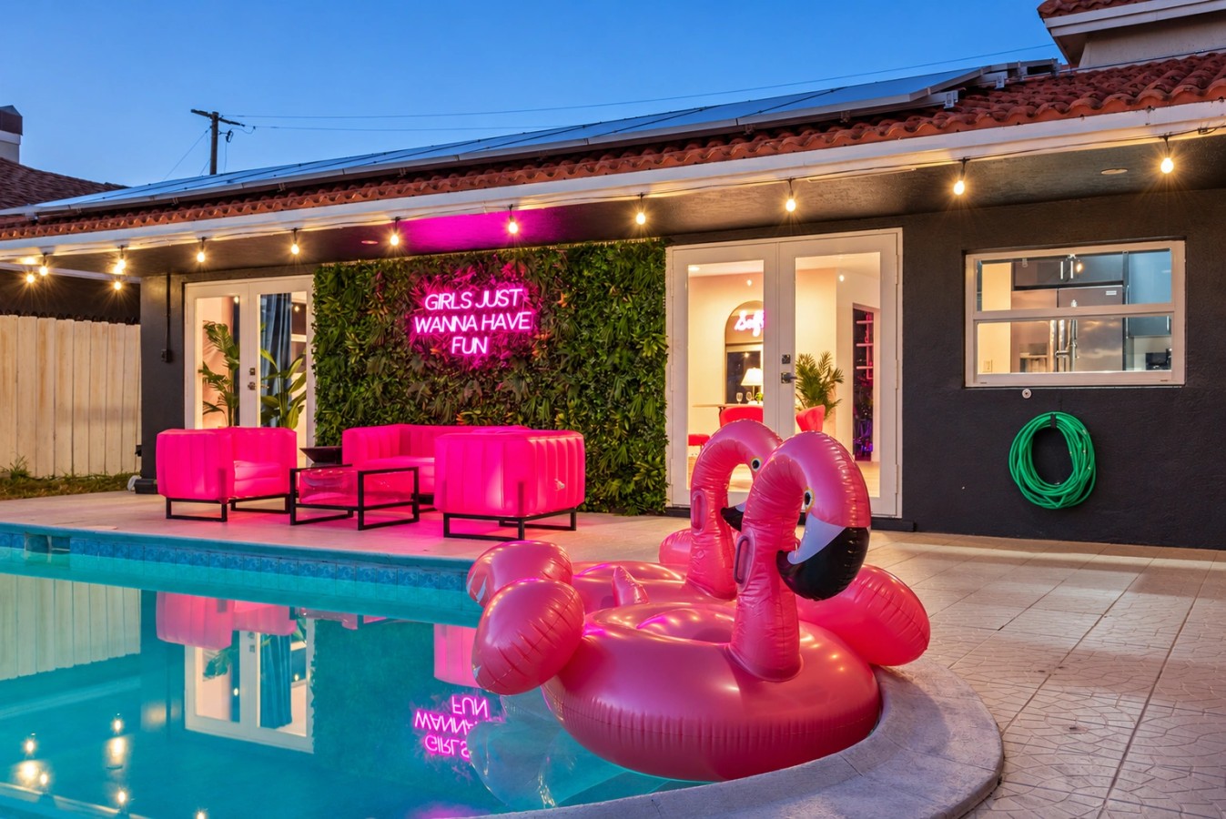 Swimming pool and bright pink patio seating at The Jungle