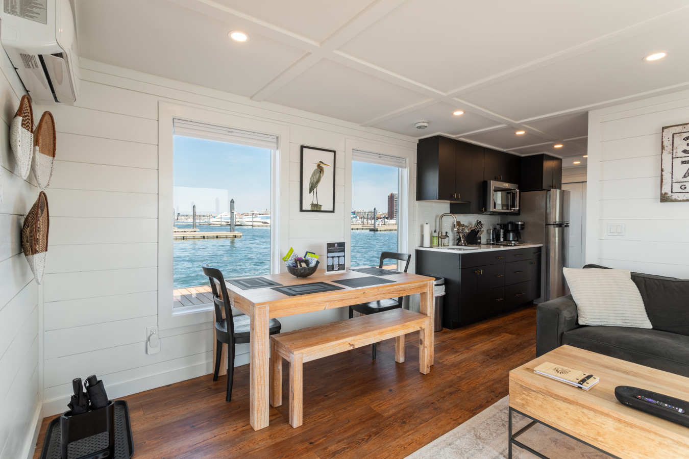 Breakfast with a harbor view — the dining table sits between the kitchen and full-width windows overlooking the water.