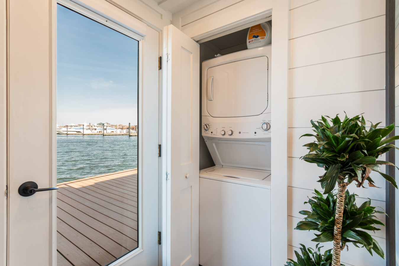 Full-size stacked washer & dryer right onboard — no laundromat runs, plus a gorgeous water view through the glass door.