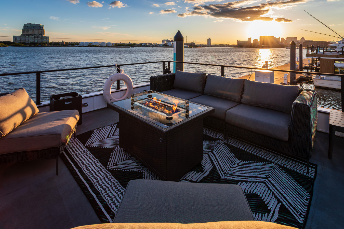 Gather around the rooftop fire pit as the sun sets over the harbor — plush sectional seating and panoramic water views.