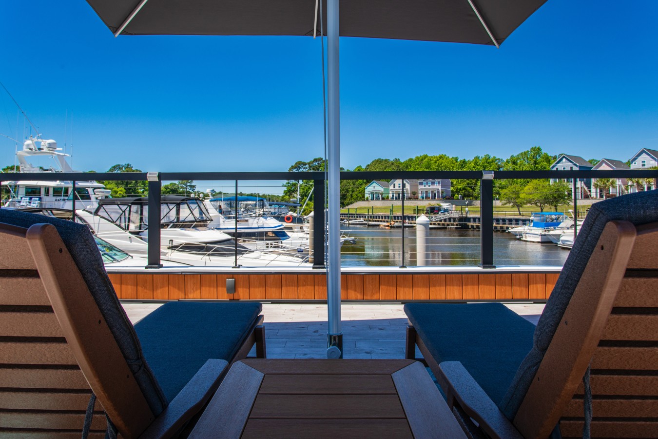 The rooftop chaise lounge view looking out over the marina, with yachts lining the docks.