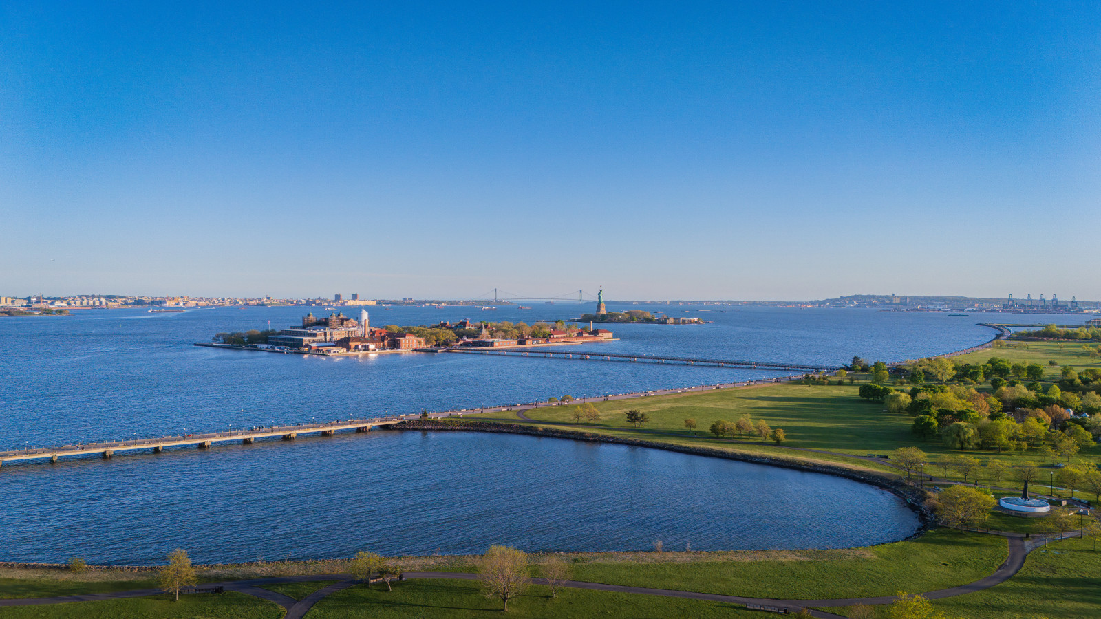 Liberty State Park from above. Ellis Island, the Statue of Liberty, and the Verrazano-Narrows Bridge on the horizon, all steps from FLOHOM 16 | Isaac's Way