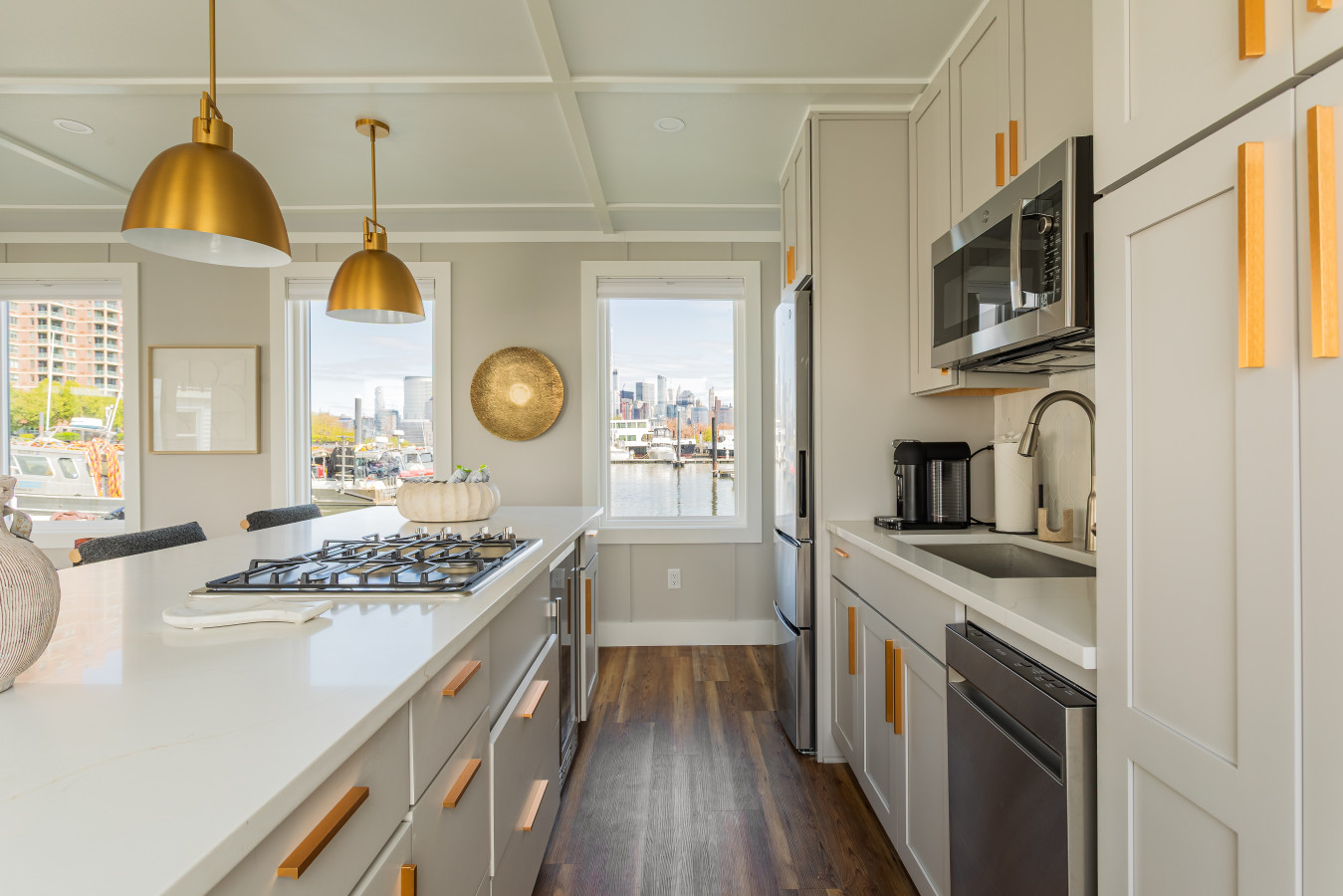 The Manhattan skyline frames itself in the kitchen window while you cook, with a gas cooktop, dishwasher, and full appliance suite within arm's reach.