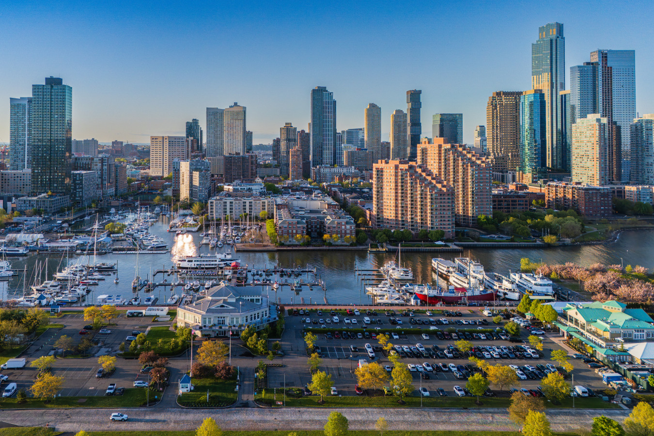 Liberty Landing Marina from above, Jersey City skyline at golden hour. The full waterfront neighborhood surrounding FLOHOM 16 | Isaac's Way