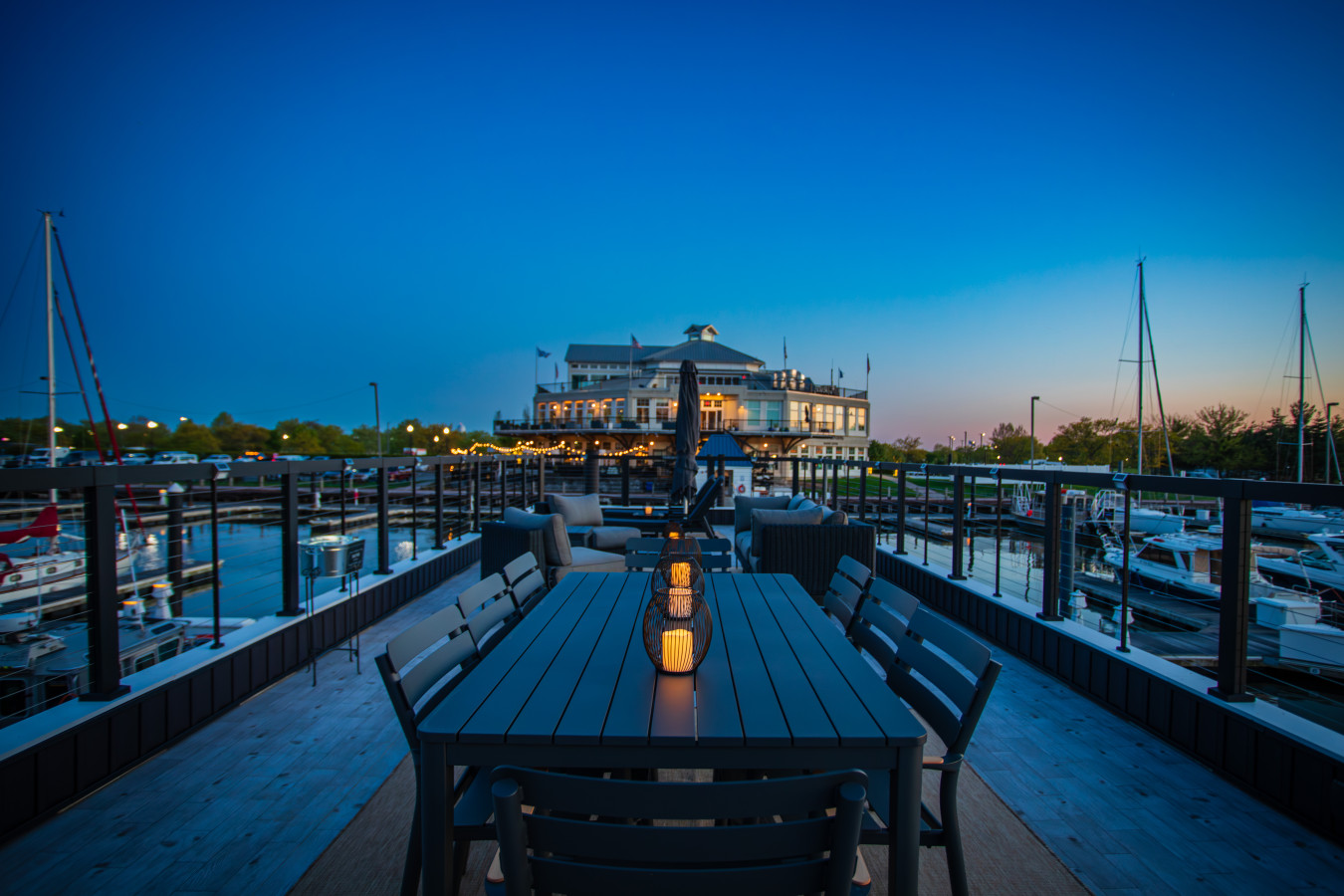 Rooftop dining table at dusk, looking toward the Liberty Landing Marina clubhouse and waterfront restaurant