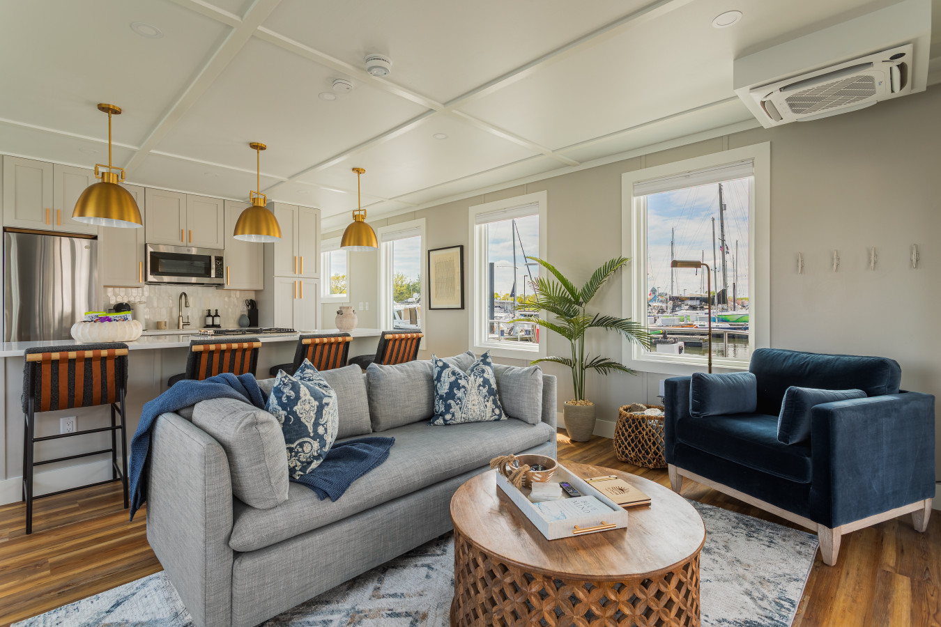 The open living and dining space flows seamlessly into a fully equipped kitchen, with marina views through every window and seating for the whole crew.