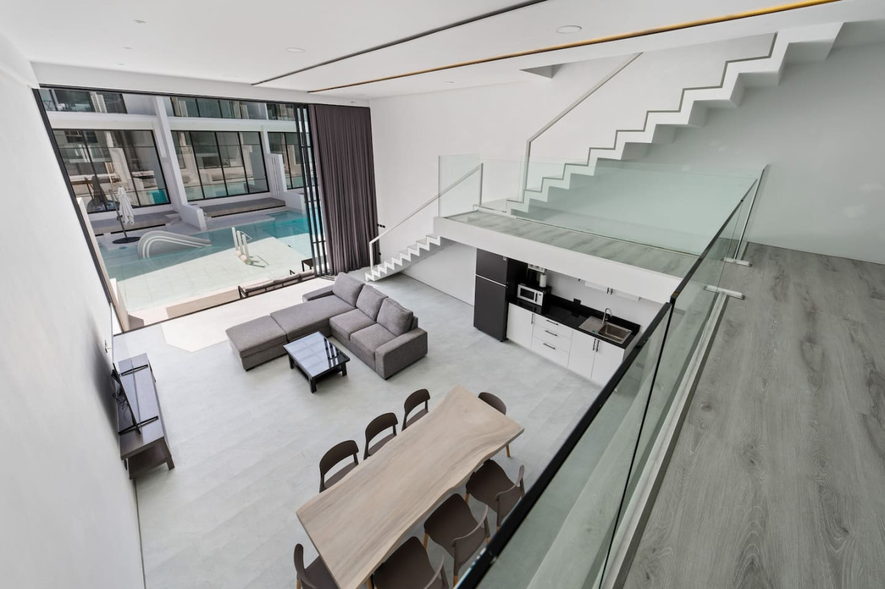 Open-plan living room with modern staircase at C'est la Vie, Replay Residence Koh Samui