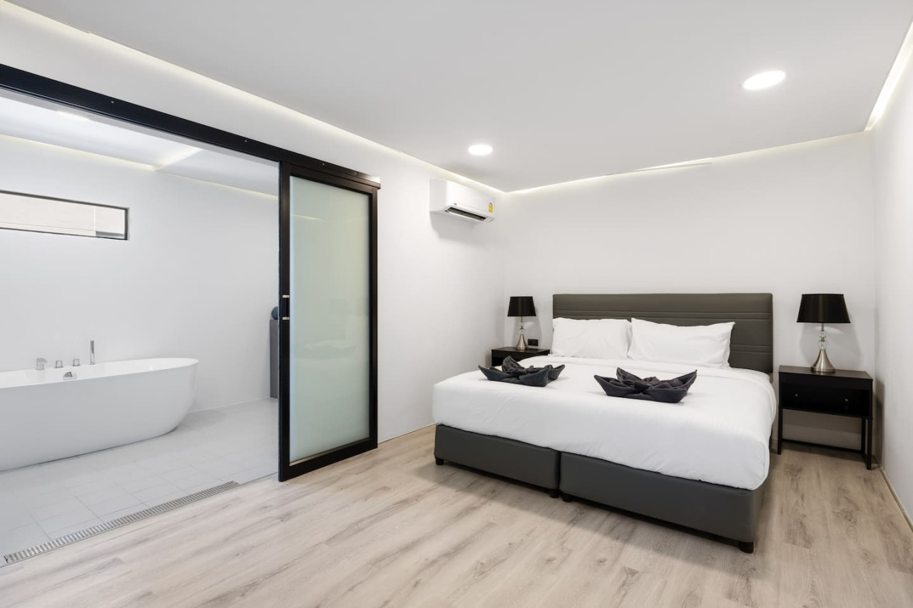 Third bedroom with plush king bed and blackout curtains for restful tropical nights