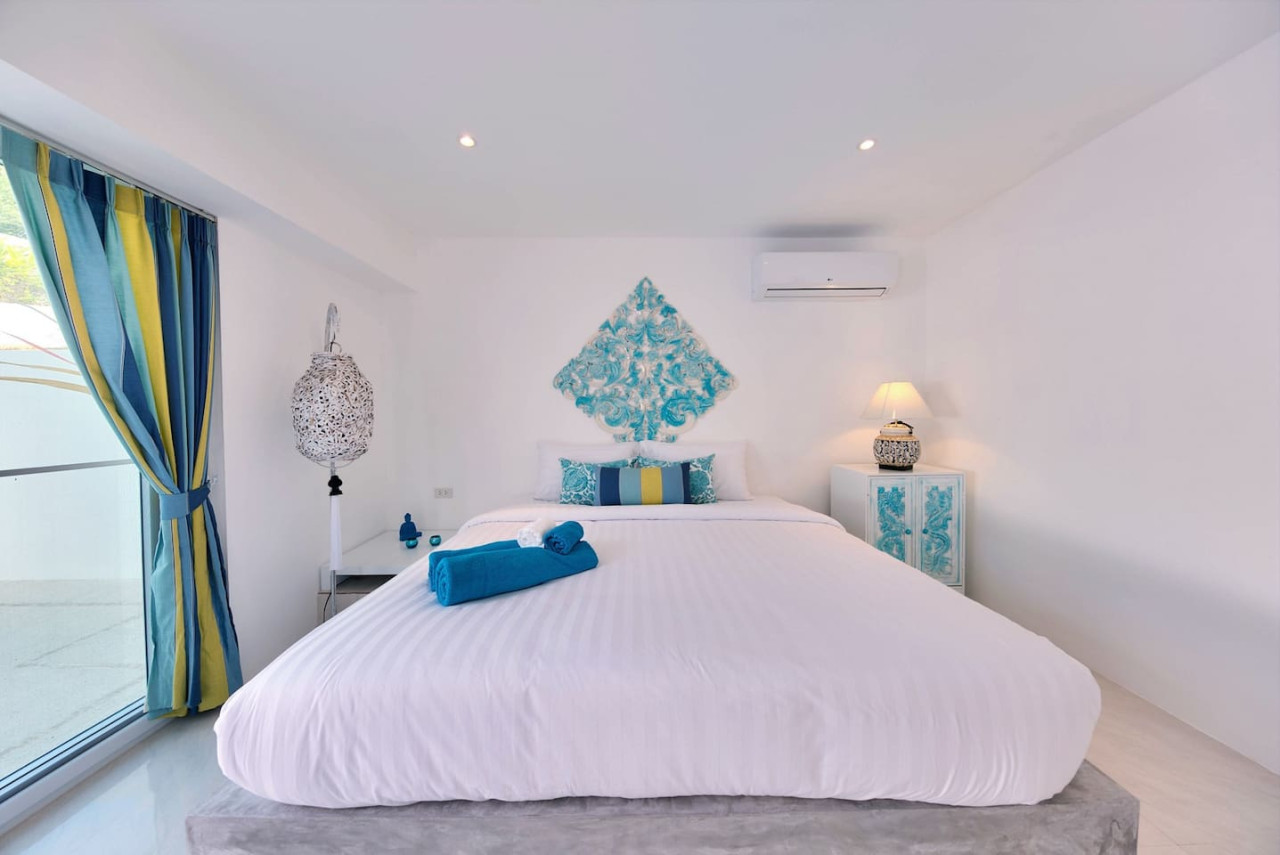 Serene master bedroom with turquoise accents and tropical views Samui