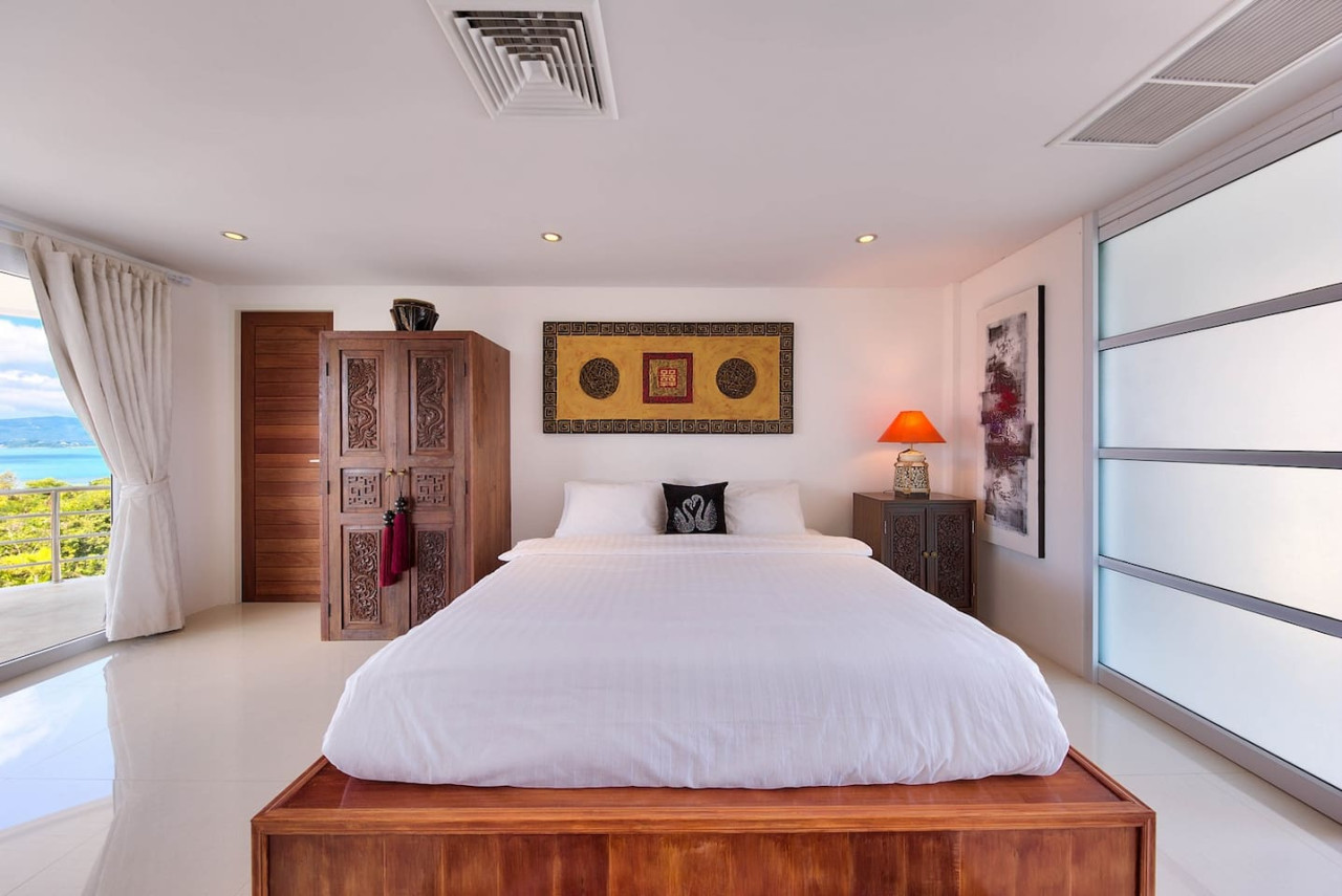 Bedroom with teak wood furniture and sea view windows Samui villa