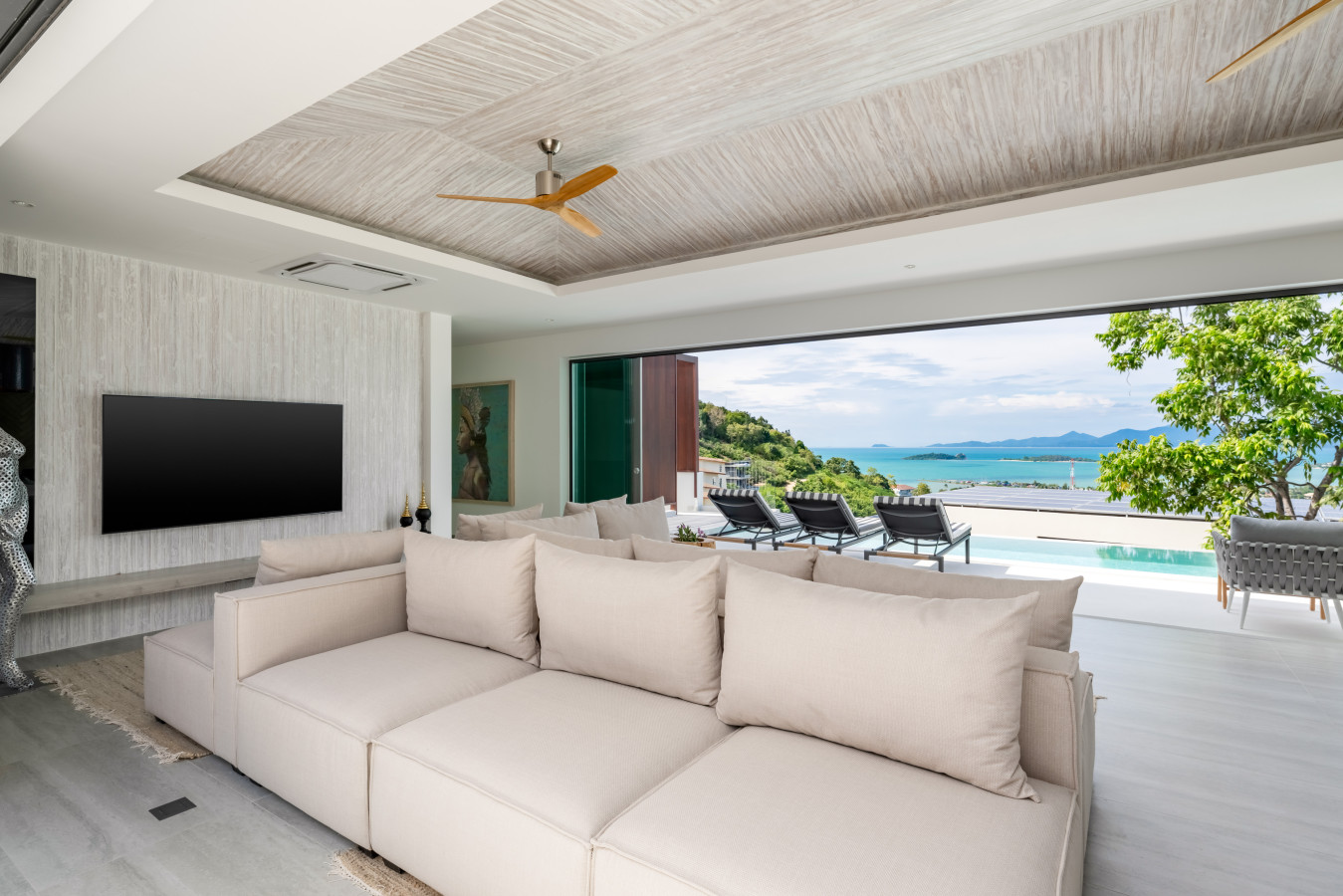 Covered outdoor lounge overlooking the pool and sea