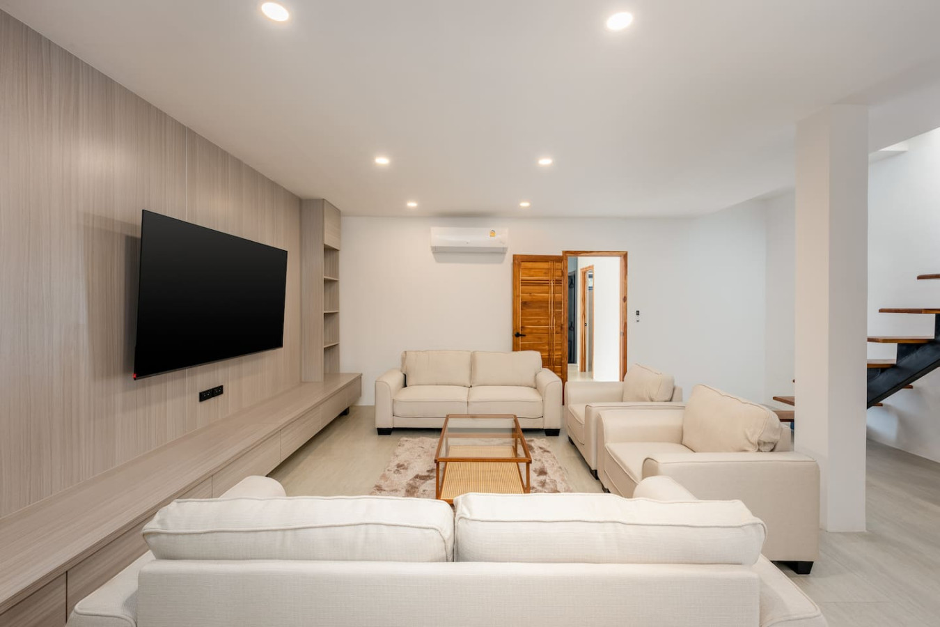 Elegant open-plan living area with feature staircase and TV lounge at Sunrise Hill Villa Koh Samui