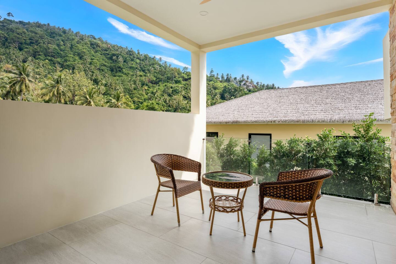 Outdoor rattan seating area with lush tropical garden views at Sunrise Hill Villa Thailand