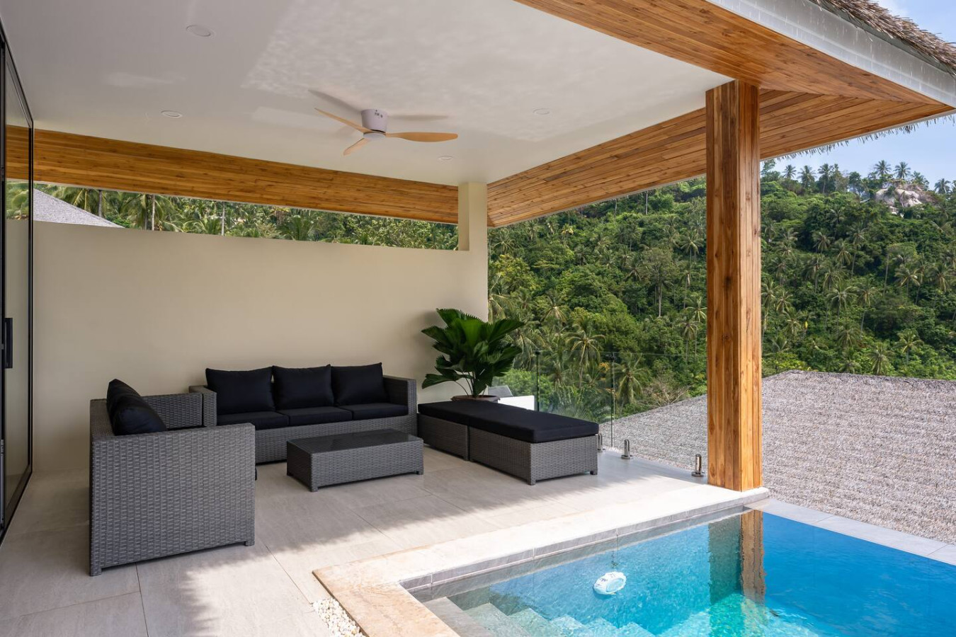 Shaded outdoor lounge with rattan daybed and tropical garden setting at Sunrise Hill Villa