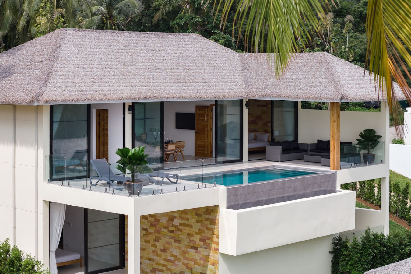 Traditional Thai-style villa exterior with thatched roof and tropical landscaping, Koh Samui