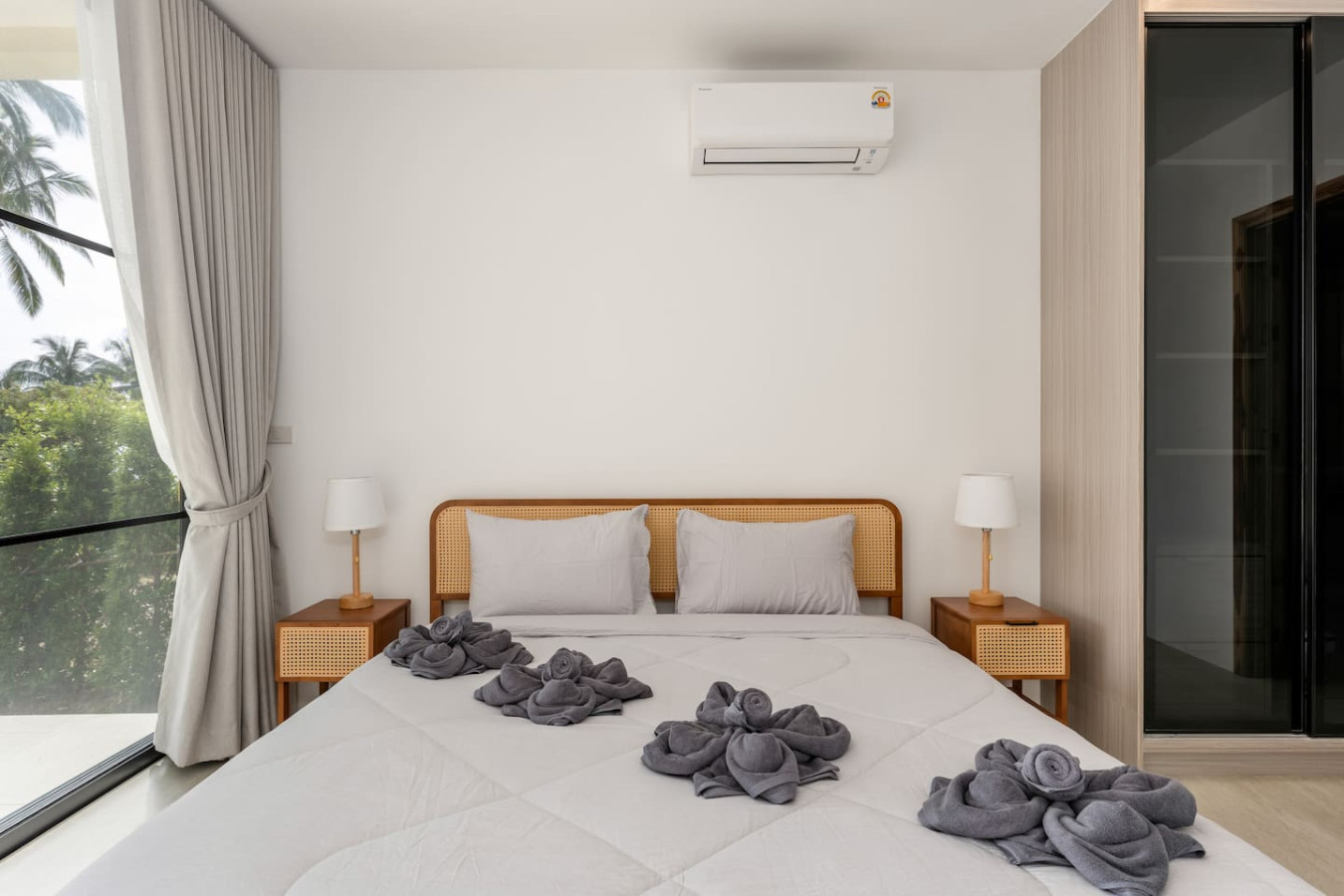Cozy guest bedroom with crisp white linens and decorative towel art at Sunrise Hill Villa