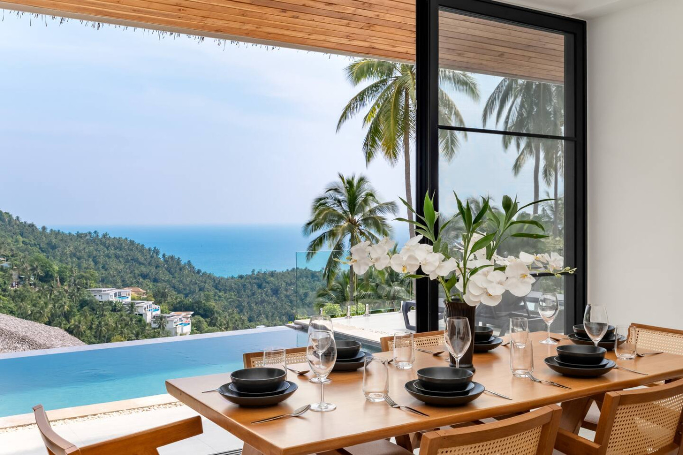 Covered outdoor terrace with rattan loungers and panoramic sea views at Koh Samui villa