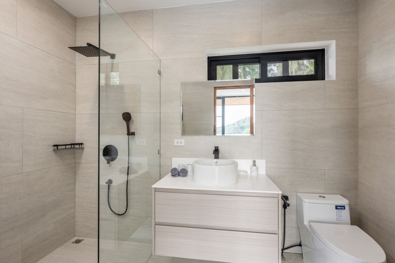 Modern white bathroom with glass walk-in shower and double vanity in Koh Samui vacation rental