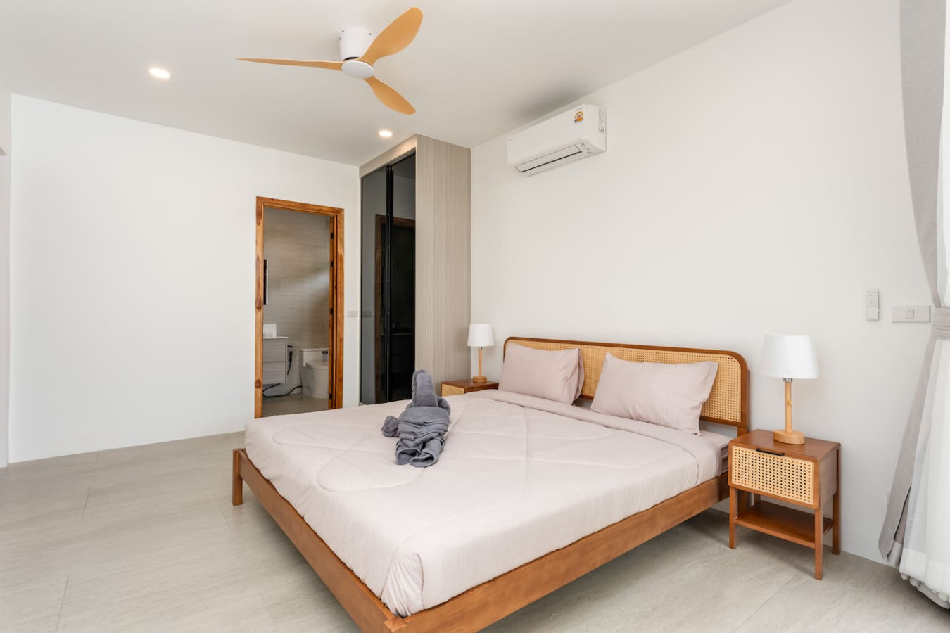Restful bedroom with wooden headboard and ambient bedside lighting at Koh Samui villa