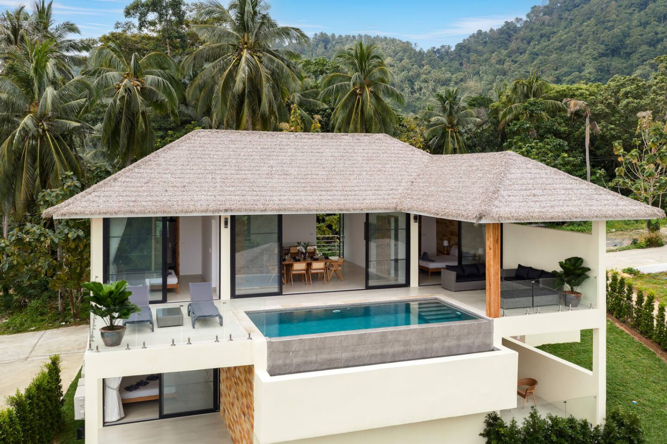 Private swimming pool with natural stone surround and tropical greenery at Koh Samui villa