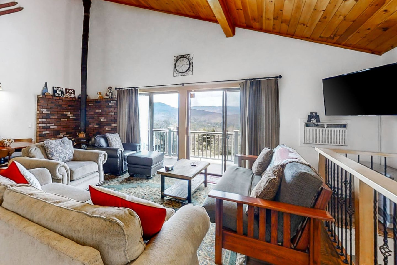 Cozy, open-concept living space with rustic decor, plush seating, large TV with cable and streaming services, vaulted ceilings, and a fully equipped kitchen.