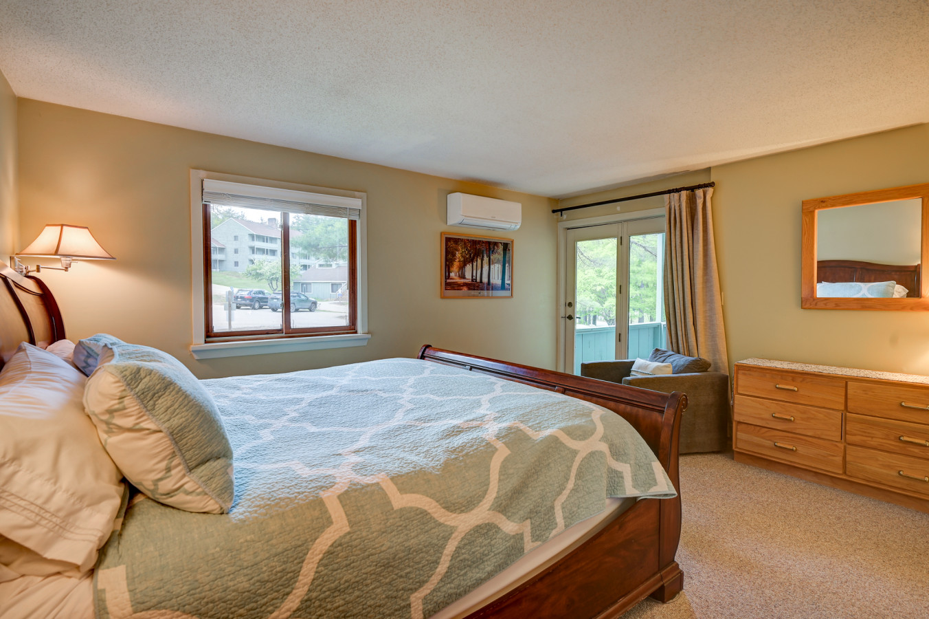 Spacious king bedroom with A/C, ensuite full bath, and private walk-out balcony for fresh mountain air.