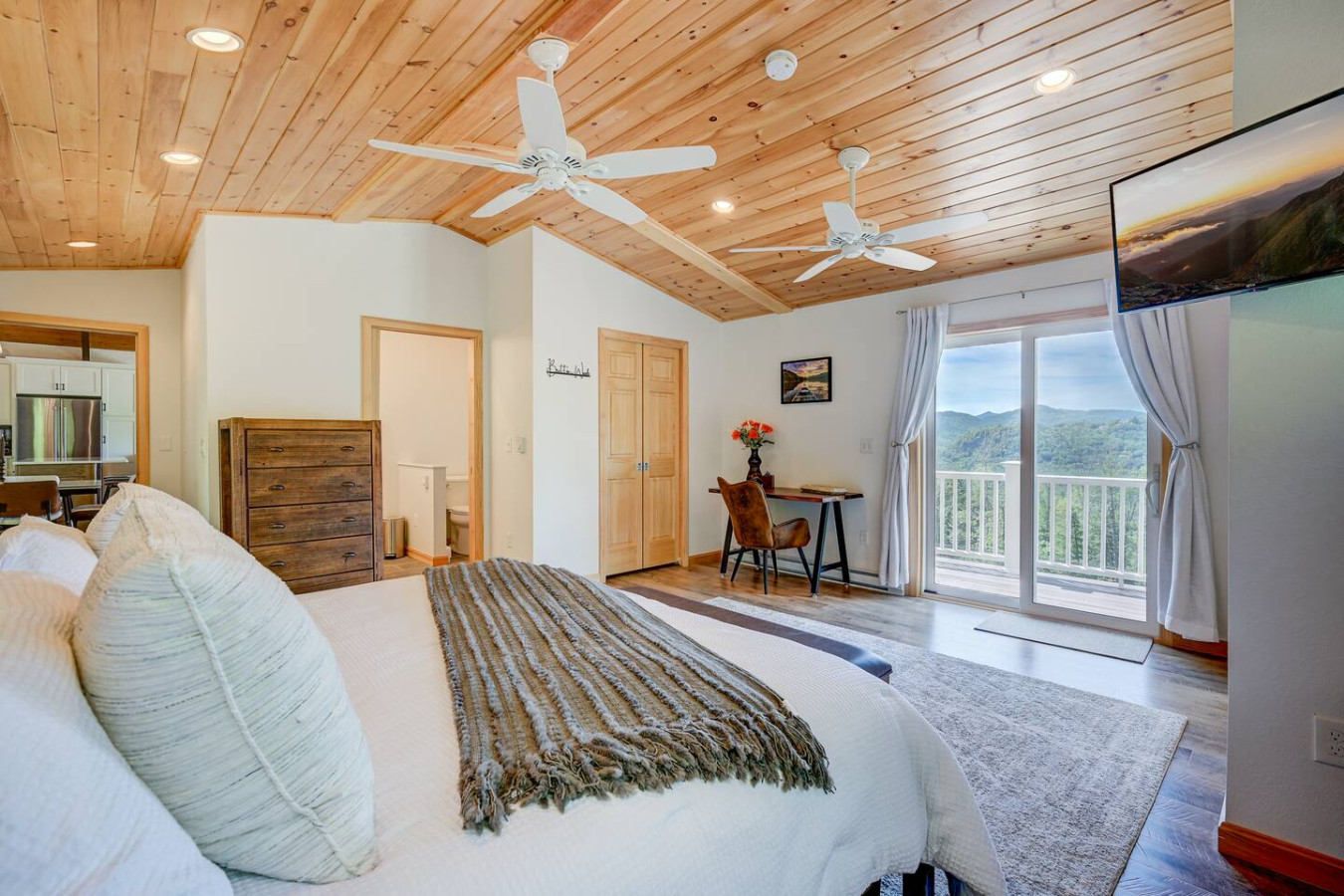 Our master bedroom features a luxurious king-sized bed, beautiful views, a TV, air conditioning, and an ensuite layout with a private, spa-like bathroom.