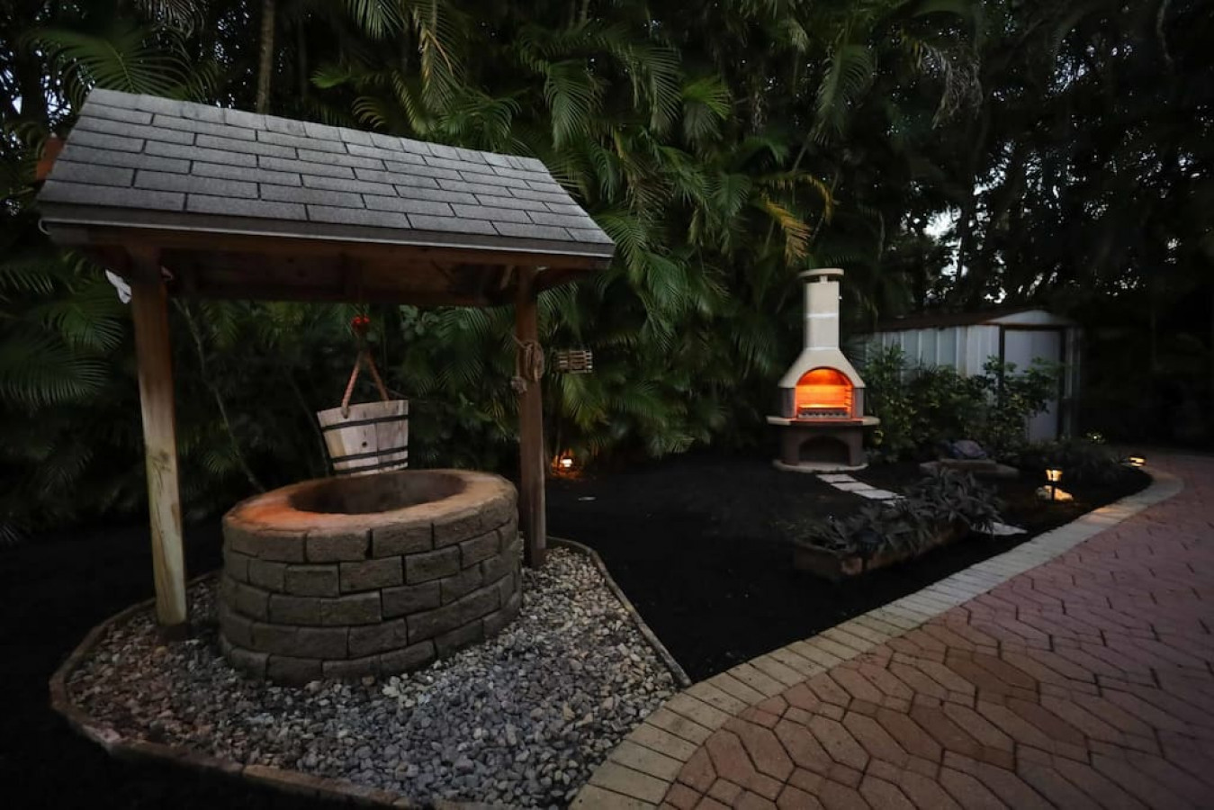 The intimate backyard landscaping comes alive at night with beautiful accent lighting