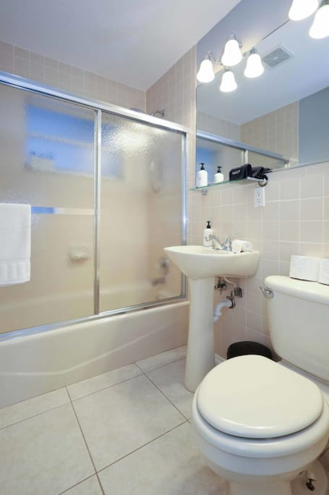 Get ready for the day in style with a glass door shower/tub combo and a huge well-lit mirror