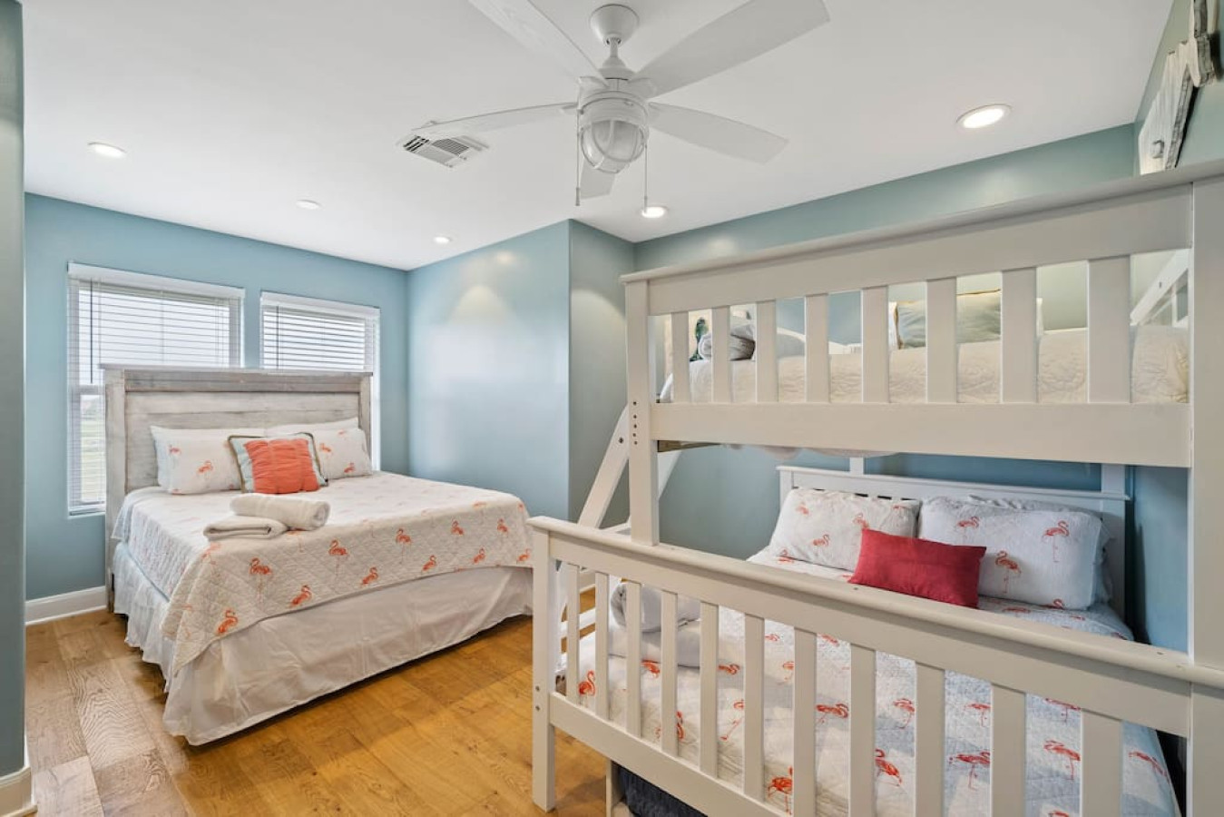 This bedroom has a queen bed and a full over full bunk bed