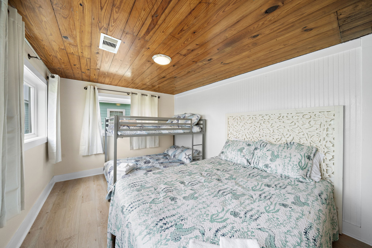 This bedroom has a queen and a full-over-full bunk bed
