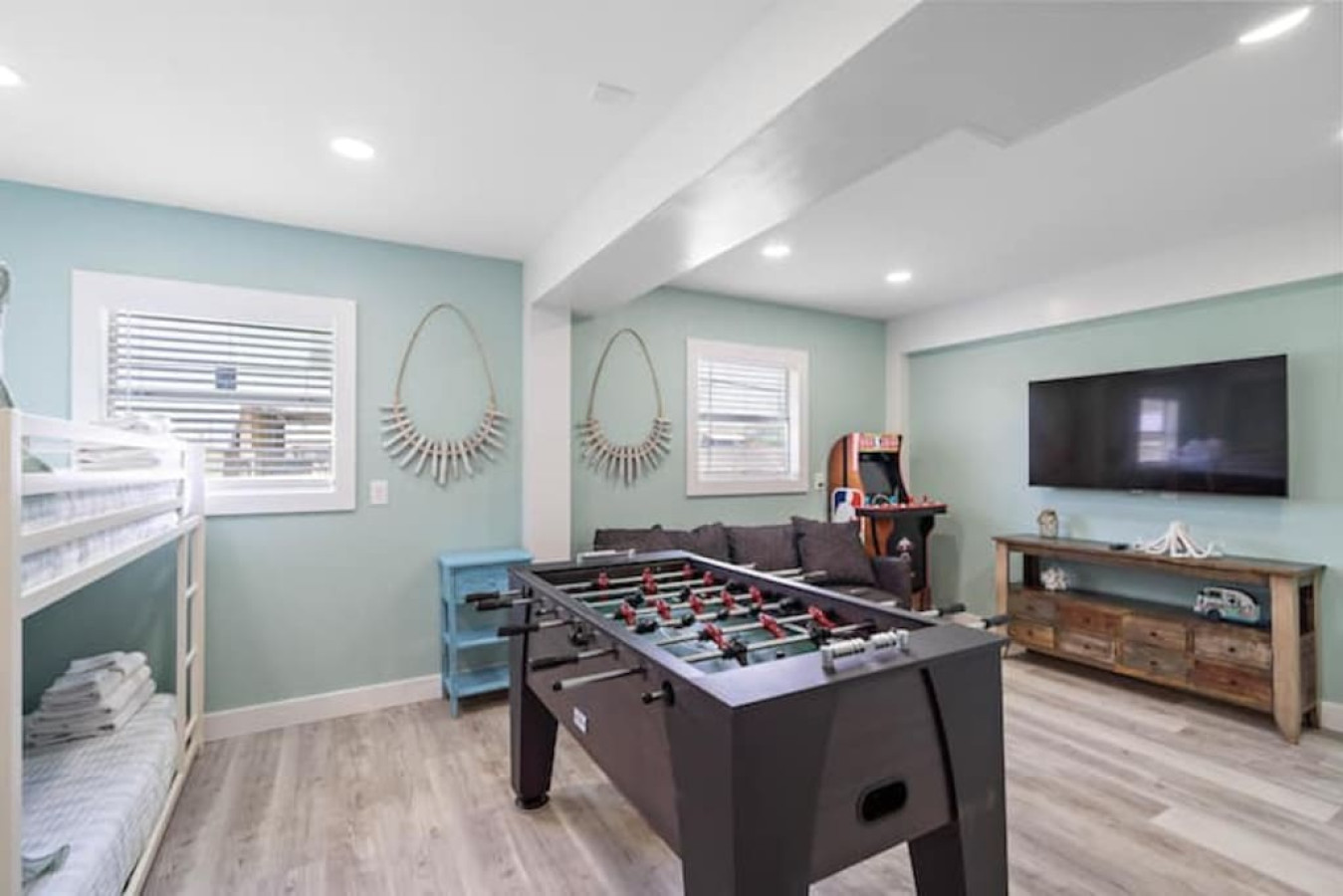 This game room is located downstairs and has a tv, foosball table, and an arcade games