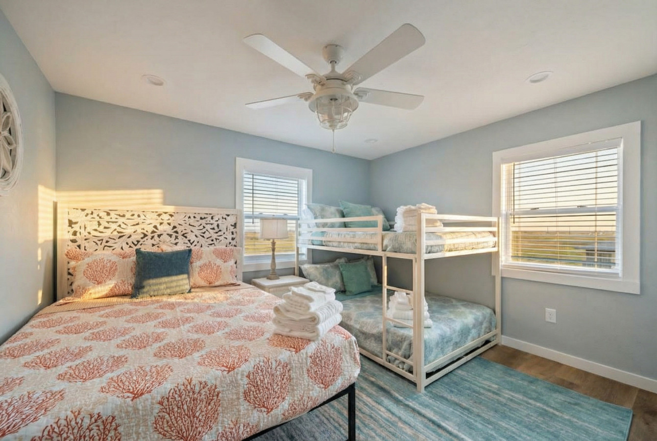 This bedroom has a queen sized bed and a twin bunk bed