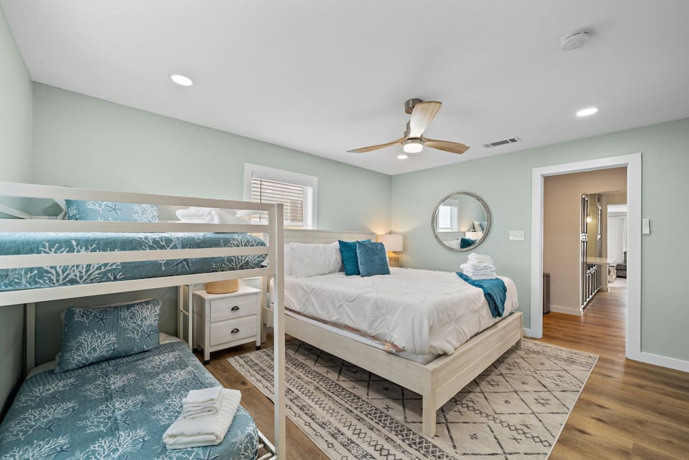 This bedroom has a queen sized bed and a twin bunk bed