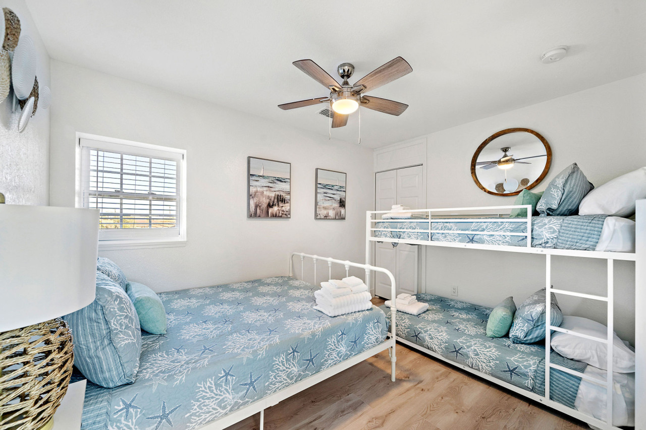 This bedroom has a queen bed and a twin-sized bunk bed