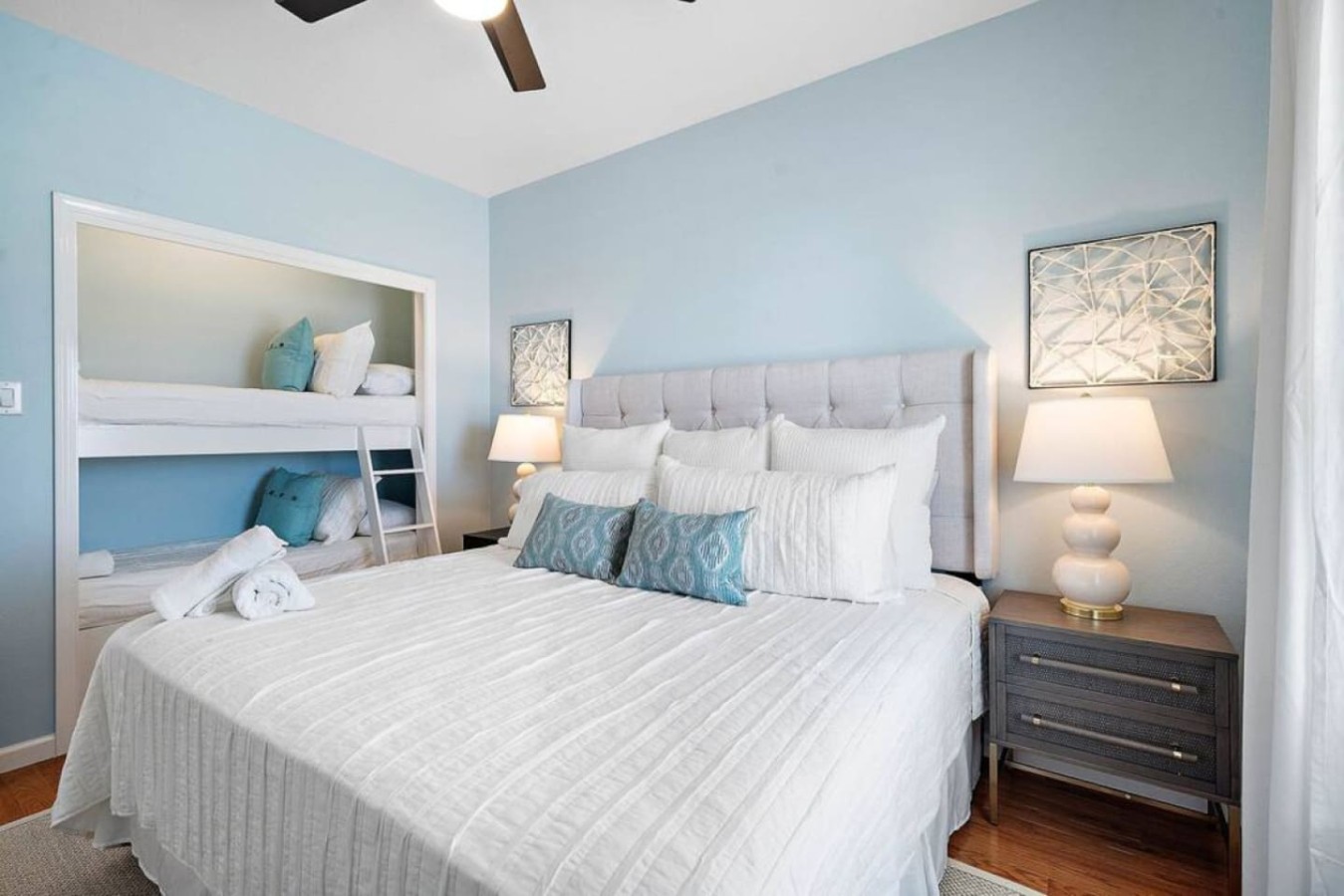 The king-size bed rests against a plush upholstered headboard