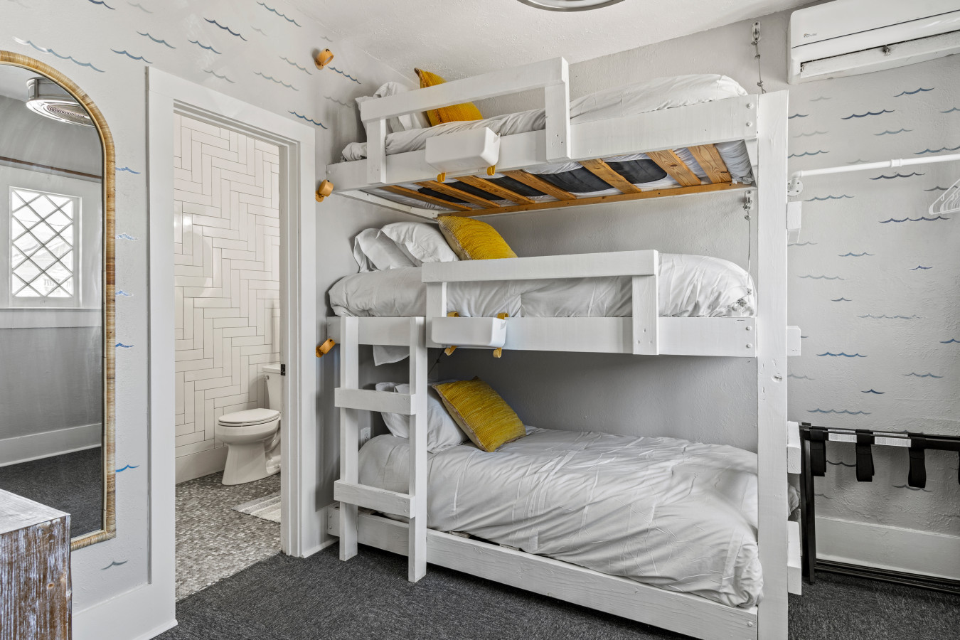 This bedroom has a triple-twin-bunk bed