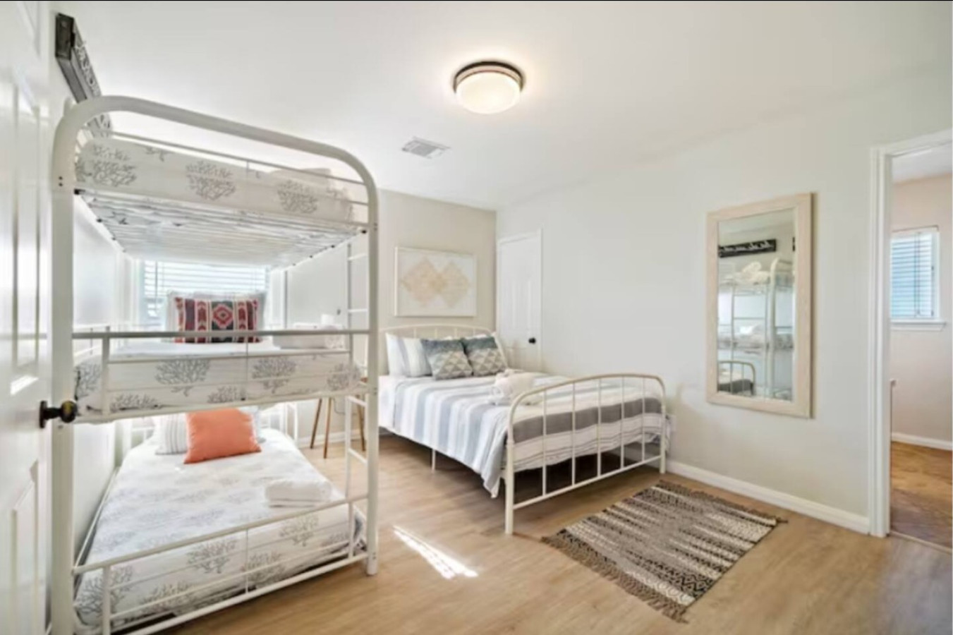 This bedroom has a queen sized bed and a twin-sized triple bunk bed