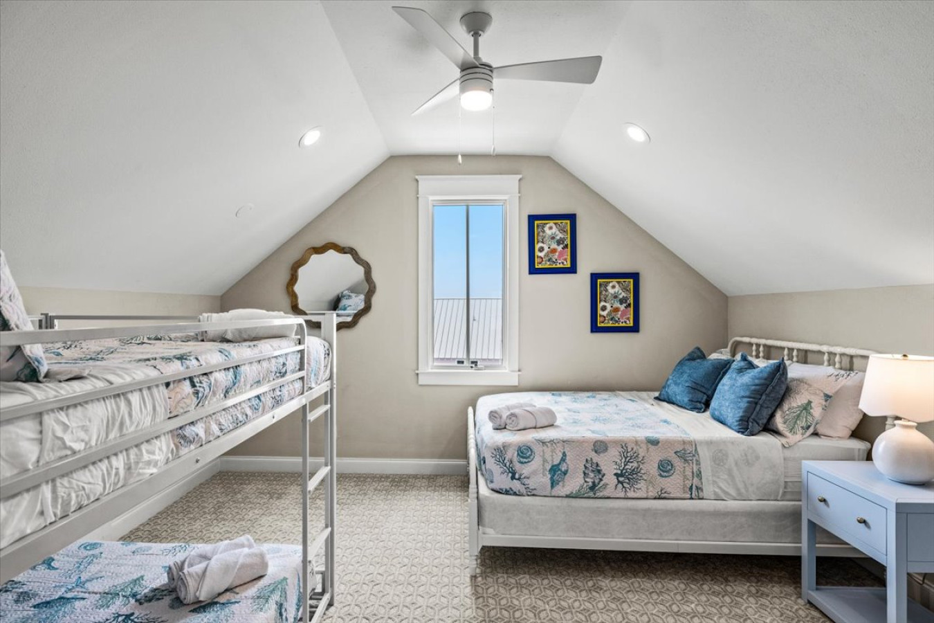 This bedroom has a queen bed and a full over full bunk bed