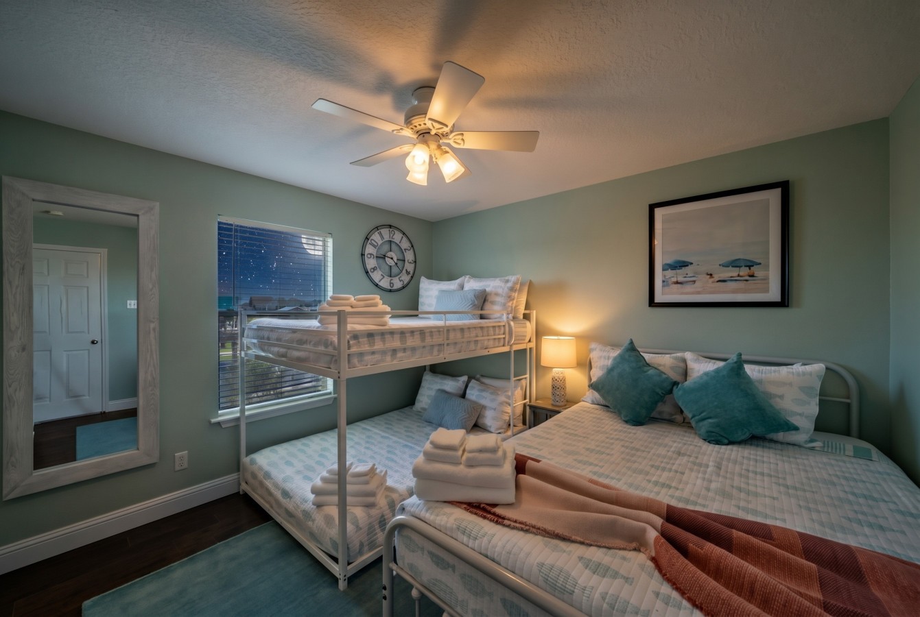This bedroom has a queen bed and a double bunk bed