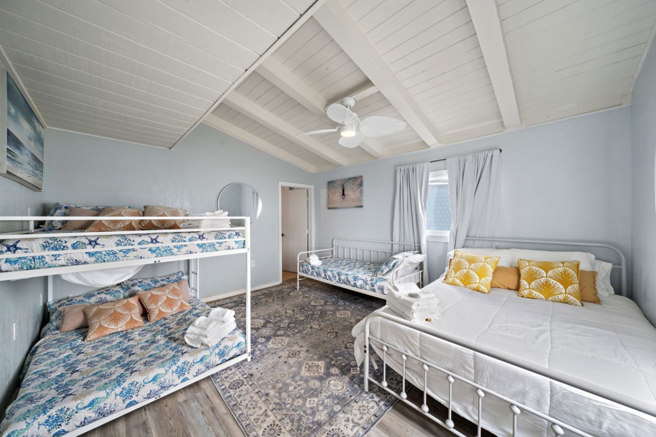 This bedroom has 1 queen bed, 1 full over full bunk bed, and a twin daybed